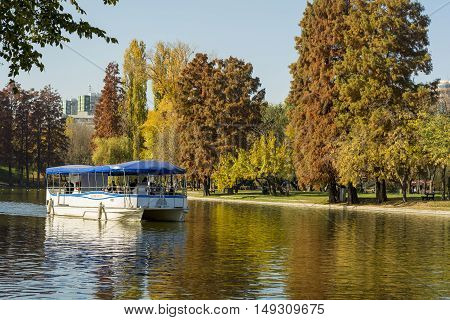 BUCHAREST ROMANIA - NOVEMBER 01: People having an afternoon tour with a small boat on the lake from Alexandru Ioan Cuza Park in Bucharest on Nobember 1 2015
