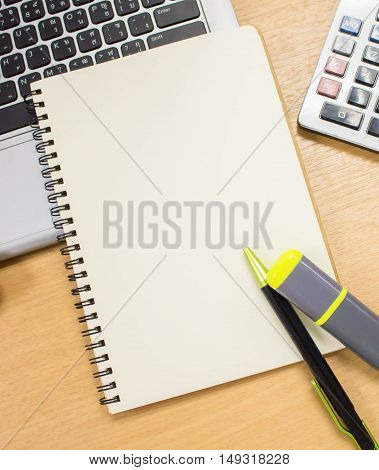 office table desk with supplies laptop calculator pen. The blank paper of book is use for putting some texts or images. Top view