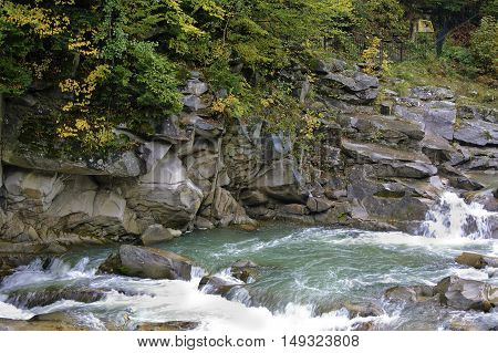 Prut river and its rapids in Carpathian mountains at rainy autumn day