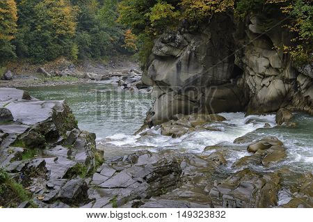 Prut river and its rapids in Carpathian mountains at rainy autumn day