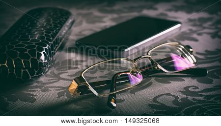 Glasses on the table and spectacle-case. Toned image. Selective focus