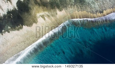 Top view aerial photo from flying drone of a wonderful nature landscape of Indian Ocean with coral bottom perfect place for snorkeling with masks. Beautiful seascape with calm waves with copy space