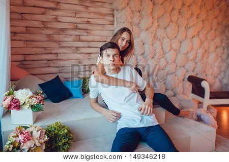 Young couple in love sitting embracing at home