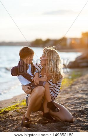 Beautiful woman with a child of four years playing on the beach near the sea