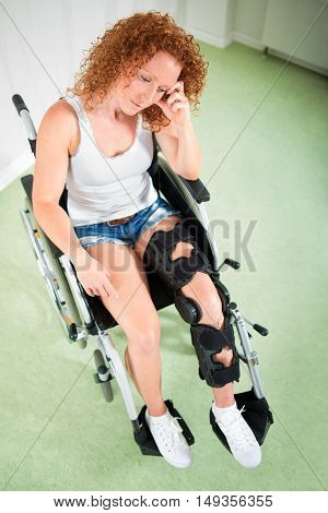 Overhead View Of Sad Woman In Leg Brace And Shorts