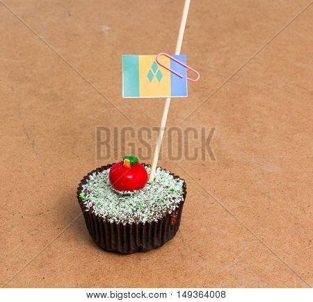 Flag of a st. vincent and the grenadines. Apple Cupcake with red apple shape bonbon on the top