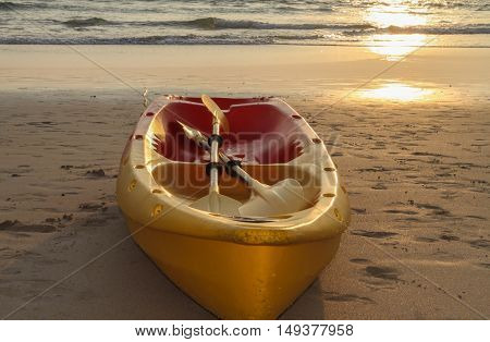 a kayaks canoe boat on the beach during sunset