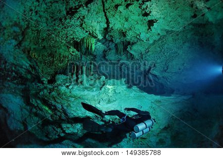 A lonely diver is swimming along the cave wall, Kukulkan cave, Yucatan peninsula, Mexico