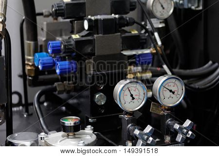 Hydraulic system of cnc machining center with gauges to control pressure. Selective focus.