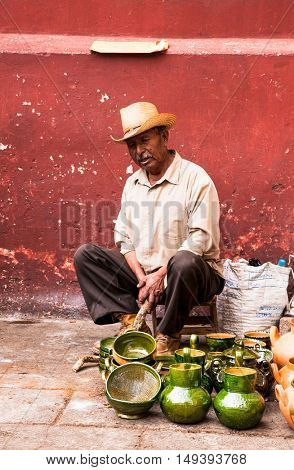 OAXACA MEXICO- DECEMBER 7, 2015: Old man selling typical handicraft pottery in a market in Oaxaca on December 7, 2015, Mexico.