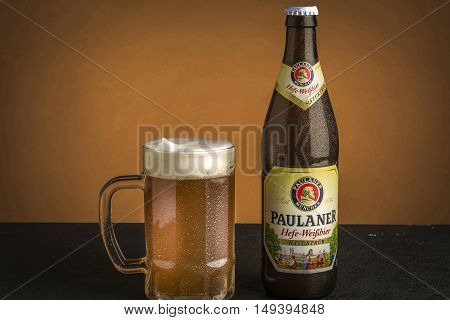 Beer jar Paulaner with beer bottle with brown background.