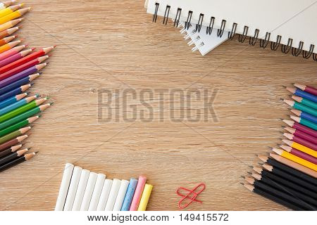 colorful stationary with pencils and a notebook