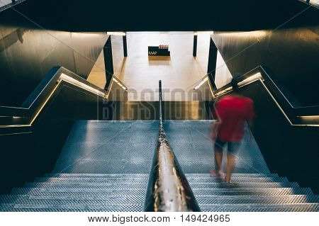 LONDON UK - AUGUST 22 2015: High angle view of stairs in Tate Modern Art Gallery interior. A blurred young is going down