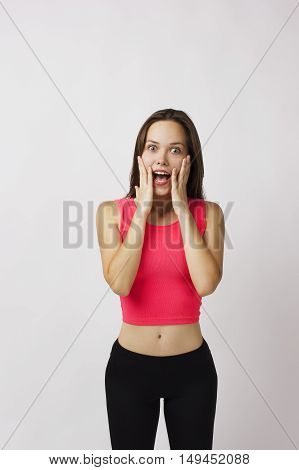 beautiful girl covers her face with her hands, showing surprise