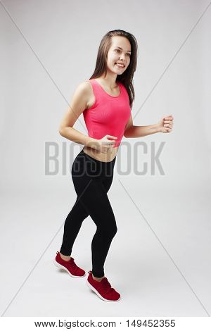 Attractive brunette girl running on a white background study
