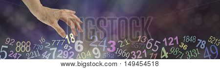 Numerology Wide Bokeh Website Banner - dark multicolored bokeh background with transparent numbers randomly placed along the bottom and a female hand choosing the number 18