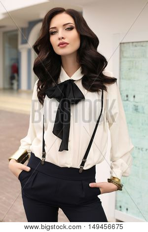 fashion outdoor photo of gorgeous woman with dark hair in elegant clothes and luxurious coat walking by autumn city