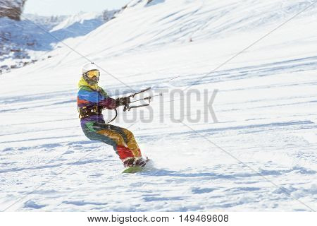 Girl snowboarder rides with snow kite. Snowkiting
