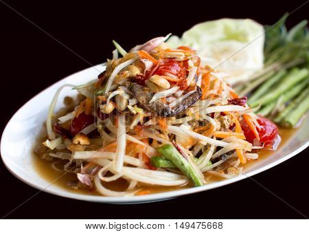 Papaya Salad Thai style (Som tum ) serve with fresh grees vegetable in black background