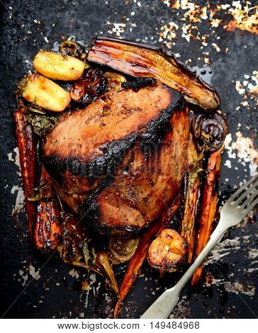 Meat baked with vegetables on a dark background. rustic style