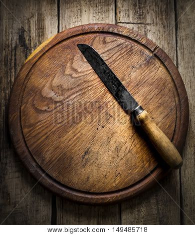 Vintage knife on a cutting board on a wooden background