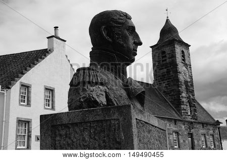 A view of a statue and the townhouse tower in Culross