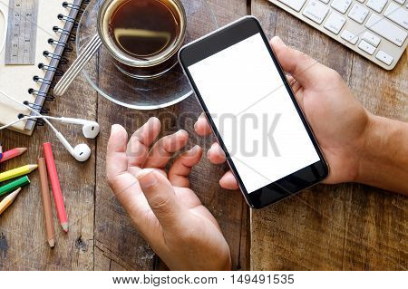 Smart phone with white blank empty screen on wood desk table in home office.