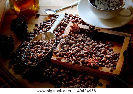 Cup of coffee beans and scoop on old rusty background