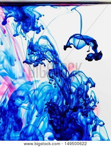 Blue and red inks flow though water creating abstract background