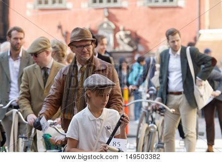 STOCKHOLM - SEPT 24 2016: Many people in old fashioned clothes in a queue leading their bicycles in the Bike in Tweed event September 24 2016 in Stockholm Sweden