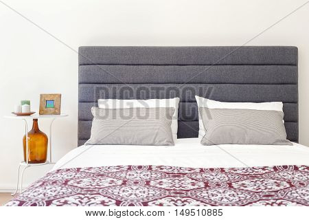 Relaxing soft bed and nightstand on a bright room