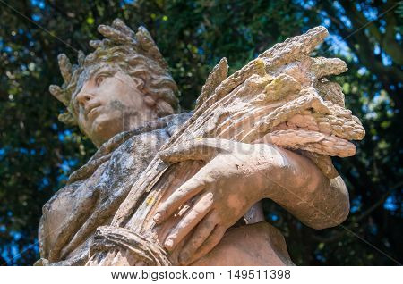 Ceramic statue of the summer with a woman holding a bundle of wheat public gardens in Caltagirone Sicily