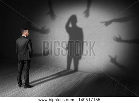 Businessman looking at his shadow where many hands reach for him forcing grab his head. Difficulties at work. Problems and issues. Predicament.