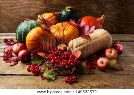 Fall concept with pumpkins apples and berries. Thanksgiving background with seasonal vegetables and fruits. Abundant harvest background.