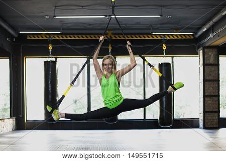 Women doing push ups training with trx fitness straps in the gym. Concept workout healthy lifestyle sport