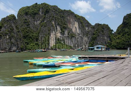Colorful kayaks on the sea in Ha long bay Vietnam with tourist boat