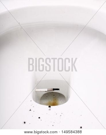 Cigarette butt in toilet bowl. Unhealthy lifestyle