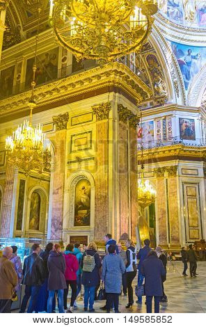 SAINT PETERSBURG RUSSIA - APRIL 25 2015: The tourists from all over the world visit St Isaac's Cathedral and admire its beauty on April 25 in Saint Petersburg.