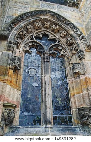 Roslin, United Kingdom - June 18, 2014. Ornate window of Rosslyn Chapel, with floral sculptures and religious frescoes.