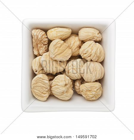 Dried unshelled chestnuts in a square bowl isolated on white background