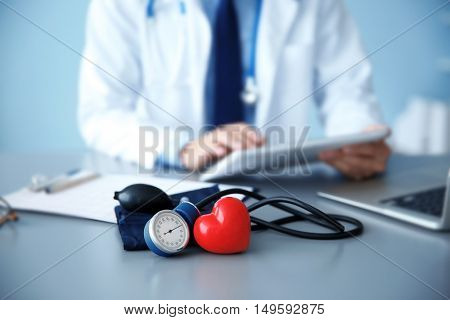 Red heart and tonometer on doctor workplace