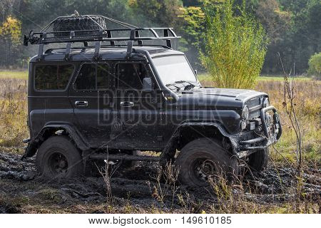 KRASNORECHENSKOYE RUSSIA - SEPTEMBER 24 2016: Black car moving in mud