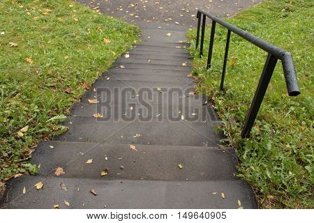 gray stone steps down and a handrail