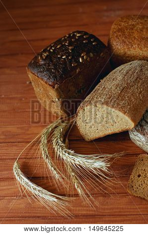 Set of different kind of bread types on wooden table made of various grains and cereal