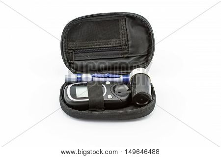 blood glucose meter the blood sugar value is measured on a finger pack in black case on white background.