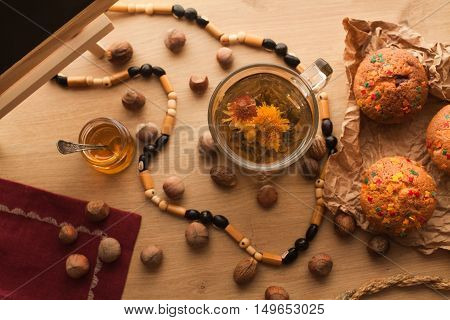 Chinese beautiful flower green tea set with fresh just baked cupcakes made with nuts and chocolate standing on wooden table. Close Up of healthy asian popular jasmine tea.