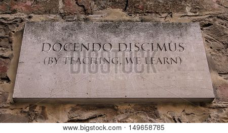 Docendo discimus. A Latin phrase meaning By teaching, we learn. Johnson State College motto.