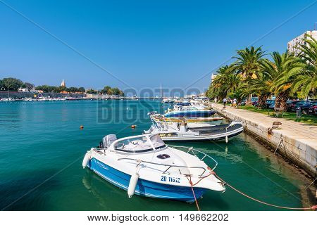ZADAR CROATIA - SEPTEMBER 14: Harbor in downtown Zadar with palm trees and walking path on a hot sunny day on September 14th 2016 in Zadar