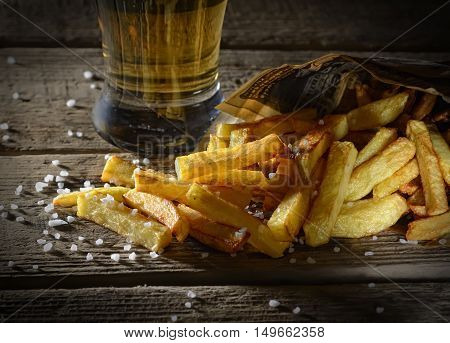 fried french fries and beer on a wooden background