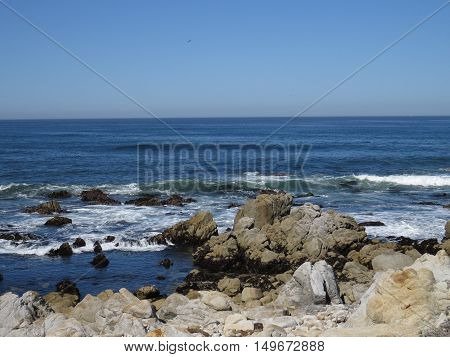 This is an image of rocks and the incoming tide at Asilomar Beach in Pacific Grove, California.
